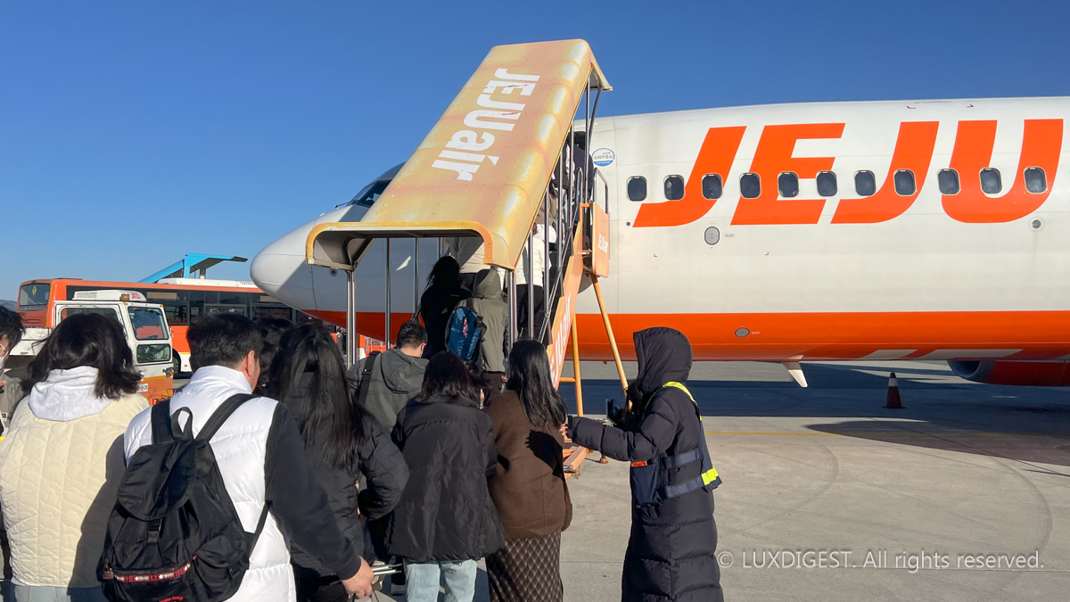 Passengers are waiting in line to board the plane. Mileage is advantageous for people who use the plane a lot.