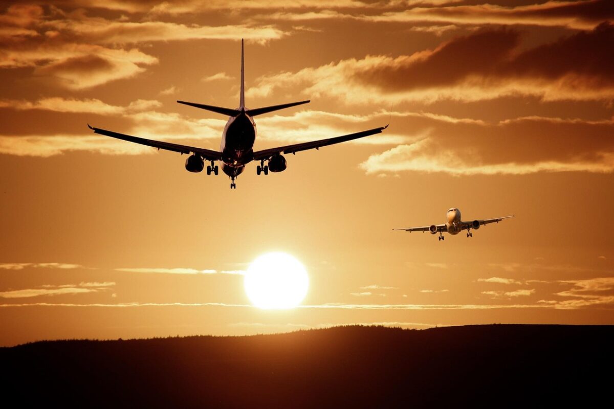 the appearance of planes taking turns taking off and landing in the sunset